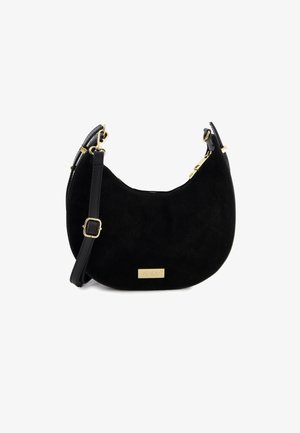 Sac à main en suède noir de forme incurvée, avec des accents en métal doré et une bandoulière réglable. Présente une plaque en or avec la marque à l'avant.