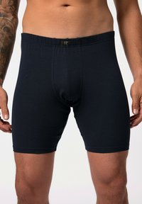 Námořnické modré bavlněné boxerky s elastickým páskem a předním kapsovým designem. Mají hladkou texturu a délku do poloviny stehna.