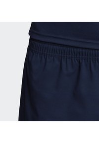 Marineblaue Sportshorts mit elastischem Bund und weichem, strukturiertem Stoff. Glatte Nähte ohne sichtbare Hardware oder Muster.