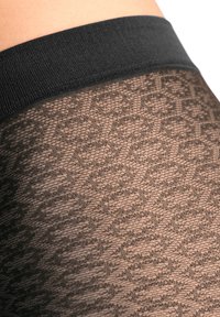 Gjennomsiktige svarte strømpebukser med en teksturert mønster og en solid svart elastisk midjebånd. Designet inkluderer et rytmisk geometrisk motiv.