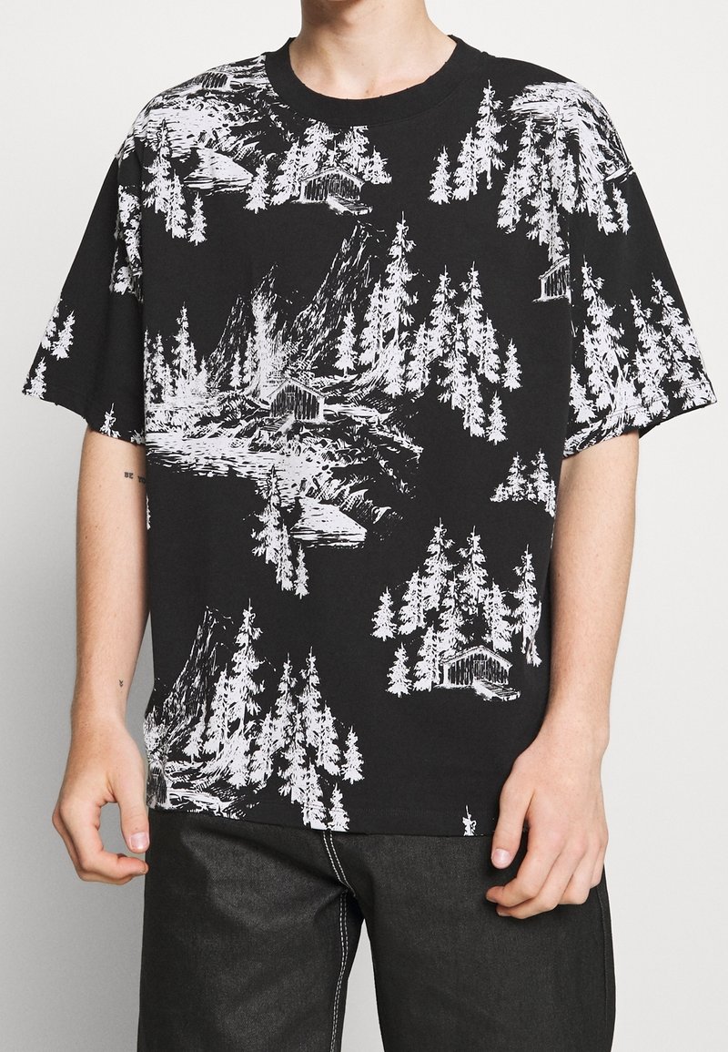 Schwarzes Kurzarm-T-Shirt mit einem weißen Grafikmuster von Wald und Bergen. Hergestellt aus Baumwolle mit einem lockeren Schnitt und Rundhalsausschnitt.