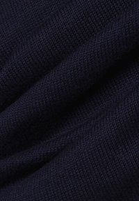 Dunkelblaues Strickgewebe mit einer glatten Textur, das eng gewebt ist und sichtbare Stiche aufweist, wodurch ein weiches, flexibles Material entsteht.