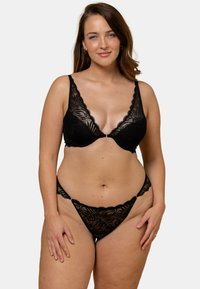 Ensemble de lingerie en dentelle noire comprenant un soutien-gorge à décolleté plongeant avec des motifs floraux et un thong assorti. Texture douce, bretelles délicates et détails de conception complexes.