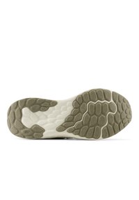 Sole of a sneaker featuring a textured olive green rubber outsole with a wavy pattern. The midsole is white and smooth.