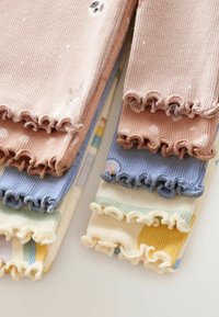 Pihe-puha pamut leggings szettek pasztell színekben: rózsaszín, kék, sárga és krém. Mindegyik ráncolt mandzsettával rendelkezik, és különböző mintákkal díszített, beleértve a pöttyöket és az állatmotívumokat.
