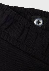 Black fabric waistband with pleated texture and a single contrasting button. Features a stretchy elastic design for comfort.