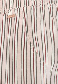 Striped light pink fabric featuring vertical lines in brown, white, and red. Elastic waistband with a small metallic brand tag.