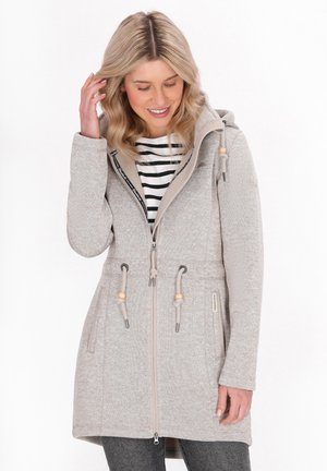 Veste zippée gris clair avec capuche, dotée de cordons de serrage avec des accents en bois, d'un tissu texturé et de poches latérales. Chemise rayée en dessous.