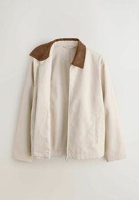 Bēša jaka ar brūnu apkakli, garām piedurknēm, daļēji atvērtu priekšējo rāvējslēdzēju un sānu kabatām, attēlota uz vienkārša fona.