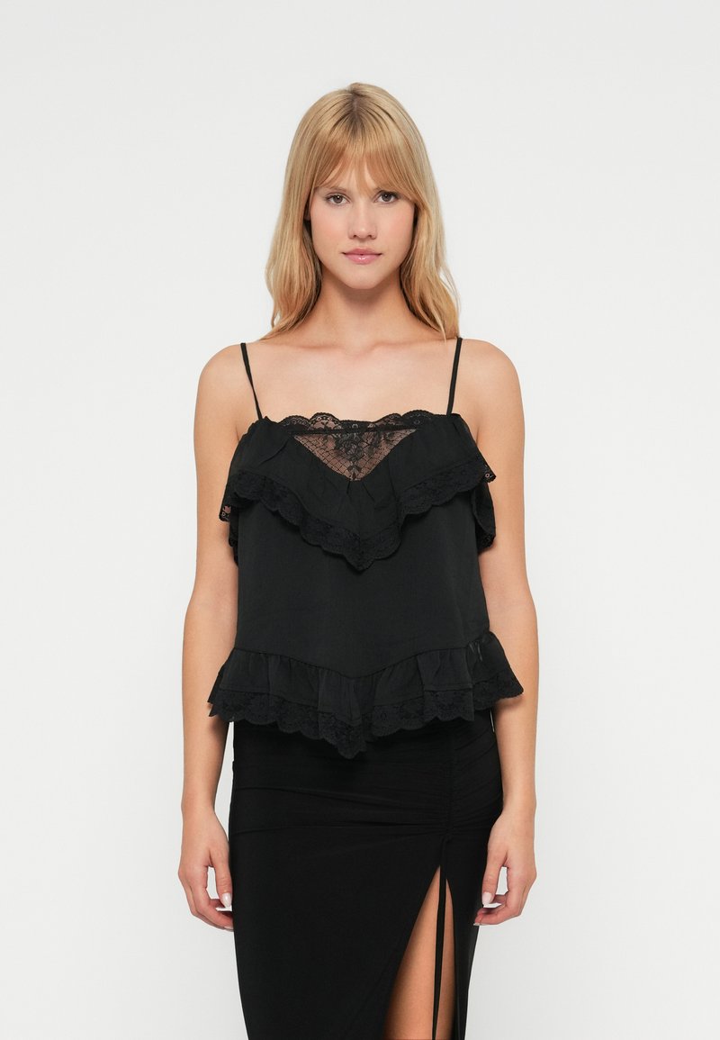 Débardeur noir avec dentelle, volants superposés et fines bretelles. Tissu doux, coupe ample, avec un panneau en dentelle en forme de V au niveau du décolleté.