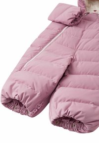 Różowy pikowany kombinezon dla niemowląt z zamkiem błyskawicznym z przodu, elastycznymi mankietami i zatrzaskami na nogawkach, zapewniający ciepło i łatwe ubieranie.