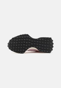 Suela de zapato de goma negra con tachuelas redondeadas y texturizadas. Parte superior rosa visible en la parte posterior, con un diseño liso y curvado. Forma plana en general.