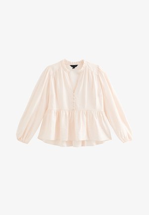 Blouse rose clair avec un col à volants, boutonnée devant et manches longues. Ourlet peplum, tissu texturé et détails froncés aux épaules.