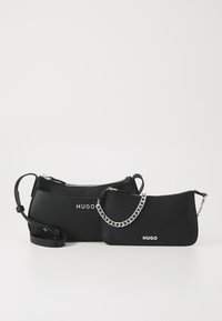 Schwarze Lederhandtaschen in verschiedenen Größen, mit Reißverschluss, silbernen Kettenakzenten und geprägt "HUGO" Logo auf der Vorderseite.