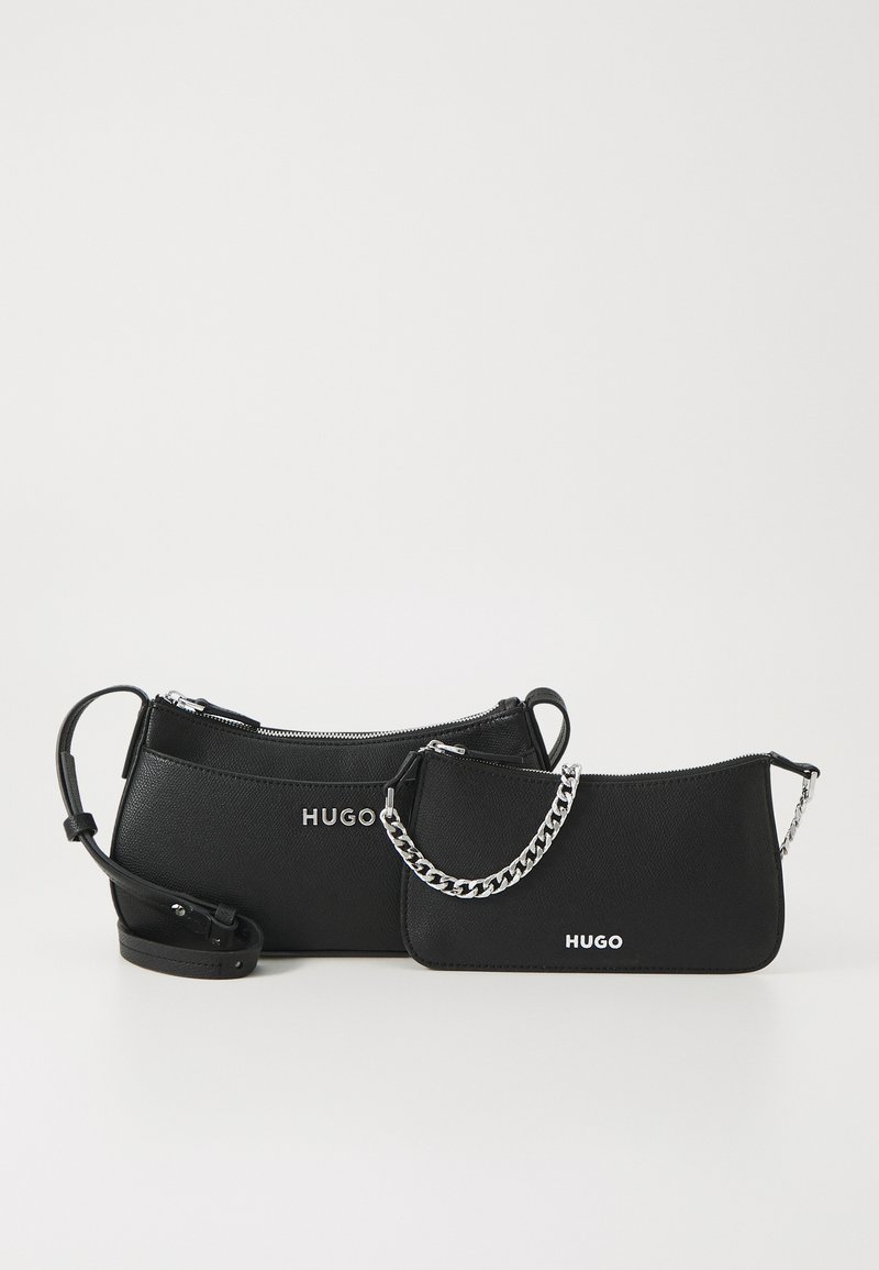 Schwarze Lederhandtaschen in verschiedenen Größen, mit Reißverschluss, silbernen Kettenakzenten und geprägt "HUGO" Logo auf der Vorderseite.