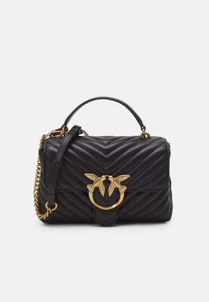 Borsa a tracolla nera in pelle trapuntata, con un inserto in metallo dorato a forma di uccello, tracolla a catena e forma rettangolare strutturata.