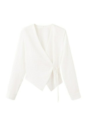 Blusa avvolgente bianca a maniche lunghe con scollo a V e chiusura laterale a nodo, realizzata in tessuto leggermente strutturato e orlo asimmetrico.