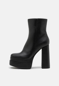 Black leather ankle boots with a chunky platform sole, high block heel, smooth texture, and minimalistic design.