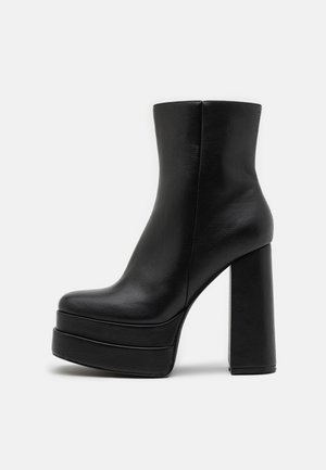 Black leather ankle boots with a chunky platform sole, high block heel, smooth texture, and minimalistic design.