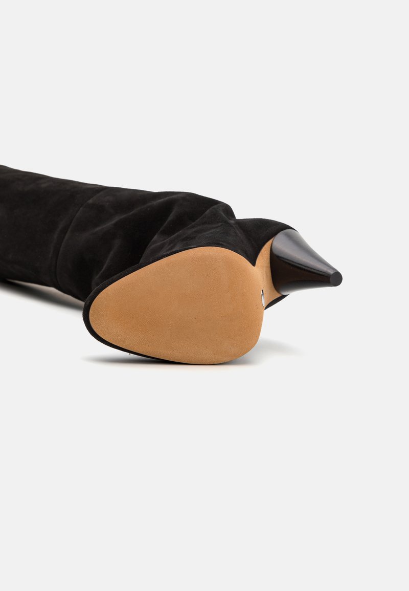 Black suede over-the-knee boot with a pointed toe and a sleek stiletto heel. Features a tan rubber sole and a smooth texture.