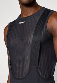 Tricou de ciclism negru, dintr-un material mesh texturat, cu bretele ajustabile cu logo-ul GripGrab. Design ergonomic pentru o potrivire optimă și confort.