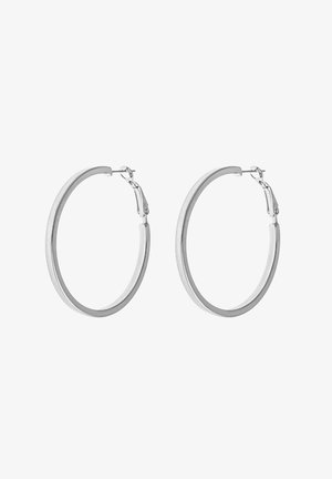 Paire de boucles d'oreilles créoles lisses en argent avec des bandes fines et arrondies et des fermoirs à charnières sur fond blanc.