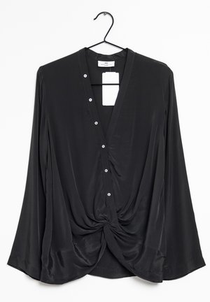 Black long-sleeve blouse with V-neck, button closure, and front twist detail hanging on a black clothes hanger against a white background.