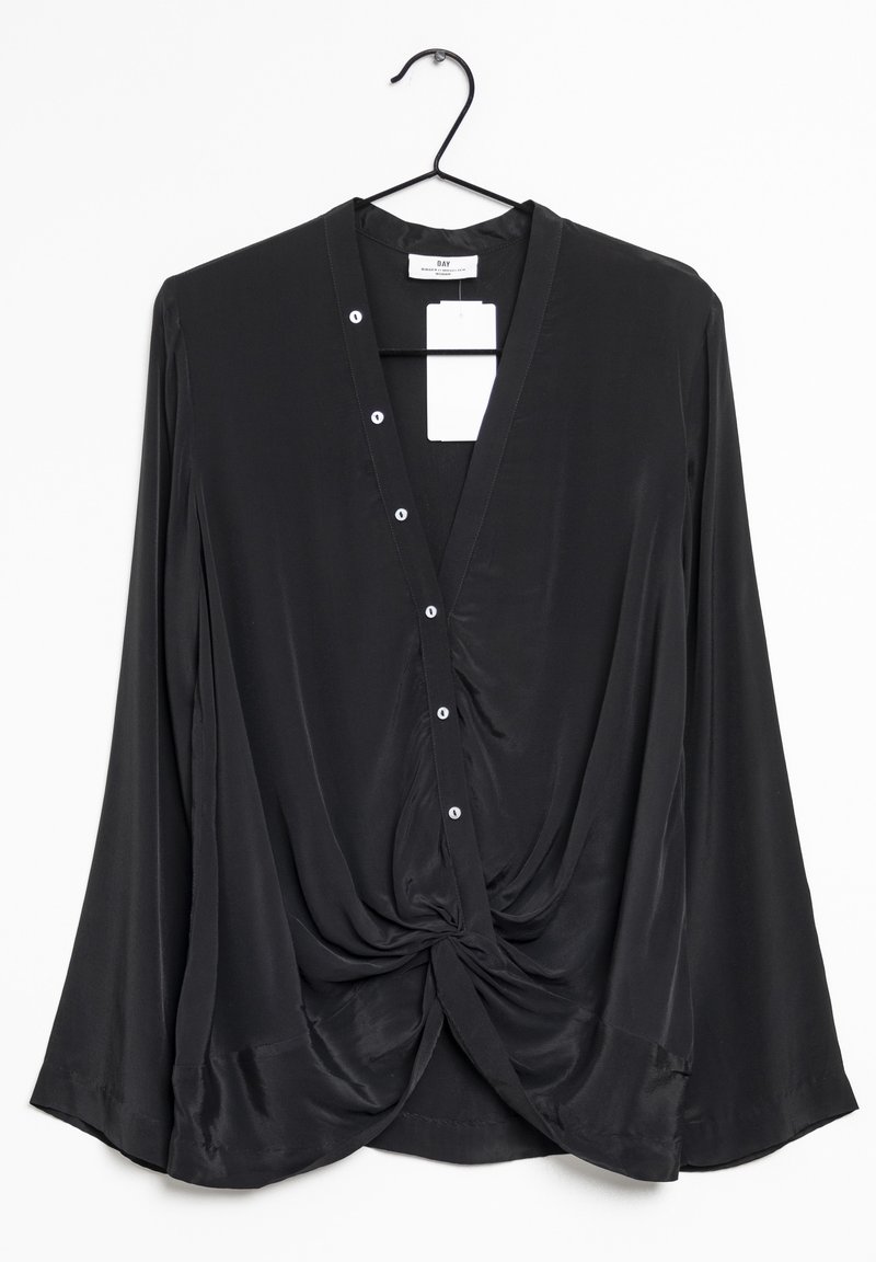 Blouse noire à manches longues avec col en V, fermeture par boutons et détail torsadé à l'avant, suspendue sur un cintre noir sur fond blanc.