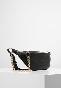 Borsa in ecopelle nera a forma triangolare, con chiusura a cerniera e tracolla in catena dorata. Presenta un anello laterale per il fissaggio. Texture liscia.