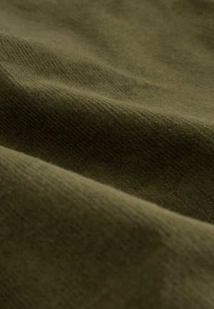 Olivgrüner Stoff mit einer sanften, strukturierten Oberfläche. Das Material zeigt subtile Rillen und Wellen, die auf eine gemütliche, stoffähnliche Qualität hinweisen.