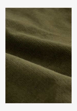 Olivgrüner Stoff mit einer sanften, strukturierten Oberfläche. Das Material zeigt subtile Rillen und Wellen, die auf eine gemütliche, stoffähnliche Qualität hinweisen.