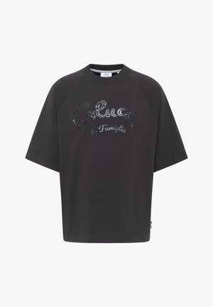Black oversized t-shirt made from soft cotton, featuring a glossy silver printed logo text "Colucci la Famiglia" on the front.