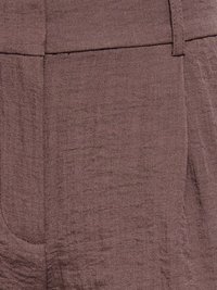 Gros plan d'un pantalon en tissu marron texturé montrant les passants de ceinture et les détails de la poche latérale.