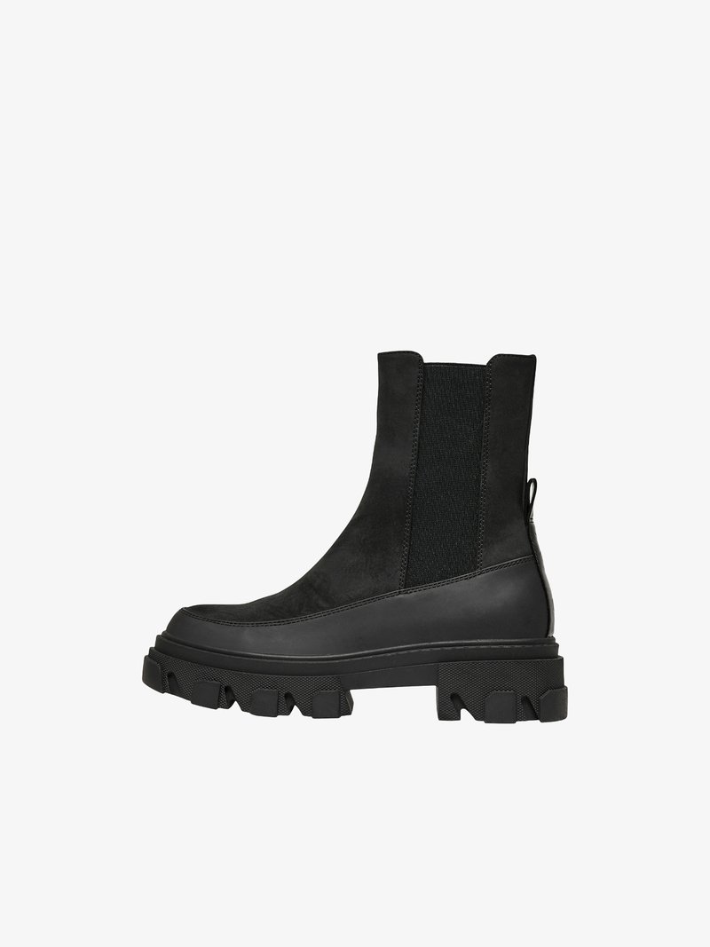 Bottines noires en suédine et matériel synthétique, avec des panneaux élastiques sur les côtés, une semelle en caoutchouc épaisse et une languette à l'arrière.