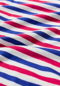 Cotton fabric featuring horizontal stripes in red, white, and blue. The texture appears soft and slightly textured. Stripes vary in width.