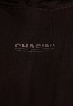 Schwarzer Kapuzenpullover mit dem Druck des Markennamens "CHASIN'" und einem Textlogo in heller Farbe. Strukturierter Stoff mit glatter Oberfläche.