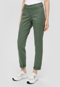 Groene katoenen broek in een blended stof met een slim fit-ontwerp, opgerolde enkels, voorzakken en een knoopsluiting, gecombineerd met witte sneakers.