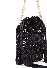 Bolso negro de lentejuelas con parte superior fruncida, que presenta una correa trenzada, herrajes de metal dorado y borlas decorativas a los lados.