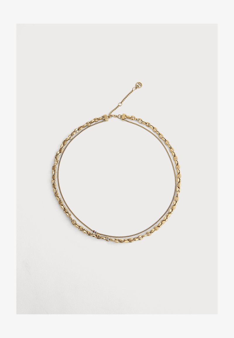 Χρυσό κολιέ διπλής στρώσης με μία χοντρή και μία λεπτή αλυσίδα συνδεδεμένες, με ρυθμιζόμενο κούμπωμα και μικρό λογότυπο.