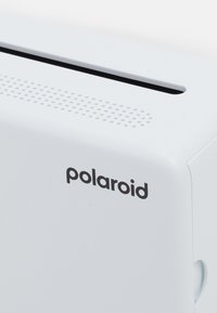 White Polaroid instant photo printer showing paper slot, ventilation holes, and brand name on smooth plastic surface.