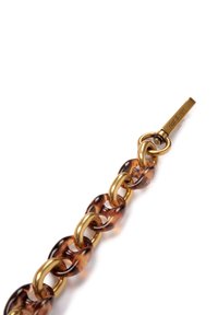 Tortoiseshell chain with clear brown links alternating with gold metal rings and a gold clip, labeled "nat & nin" on the metal.