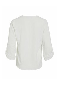 Hvid langærmet skjorte med opfoldede manchetter, lavet af letvægtsstof, med et enkelt design og tekstureret overflade på bagsiden.