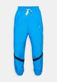 Blue athletic pants made of lightweight fabric. Features an adjustable waistband with yellow drawstring, black accents, and side mesh panels.