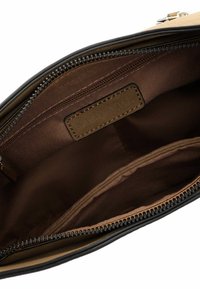 Doublure intérieure en tissu marron et beige d'un sac, avec une fermeture éclair et une étiquette en cuir. Texture lisse avec des détails de couture soignés.