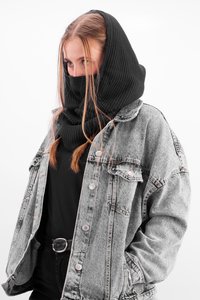 Black knitted cowl neck scarf layered over a black top, paired with a gray denim jacket featuring silver buttons and a relaxed fit.