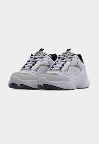 Ζευγάρι λευκά και γκρι αθλητικά παπούτσια Fila με μαύρες λεπτομέρειες και σχέδιο φίδι, τοποθετημένα δίπλα δίπλα σε ουδέτερο φόντο.