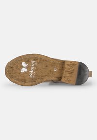 Suela de calzado marrón con material natural texturizado, con logotipo e indicaciones de talla impresas. Acabado duradero en color negro en el tacón.