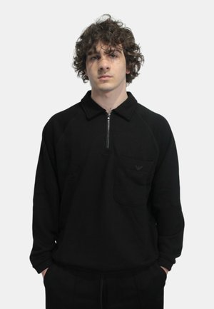 Felpa nera con zip a quarto, tasca frontale e dettagli con logo. Caratterizzata da maniche raglan e un tessuto testurizzato.
