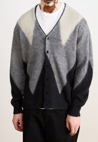 Grå och svart cardigan med ett geometriskt mönster, med V-hals, långa ärmar och knäppning. Tillverkad av mjukt, texturerat tyg.