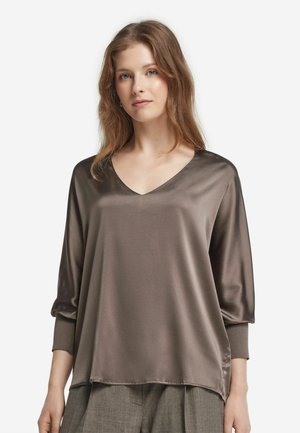 Blusa in satin marrone con scollatura a V, maniche a tre quarti e vestibilità rilassata. Texture liscia con un drappeggio fluido.